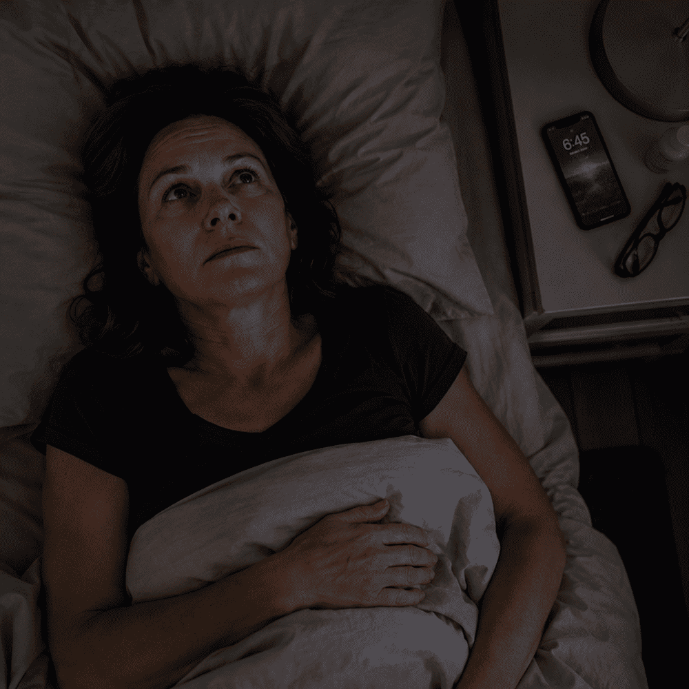 A woman lying awake beside a phone showing 6:45